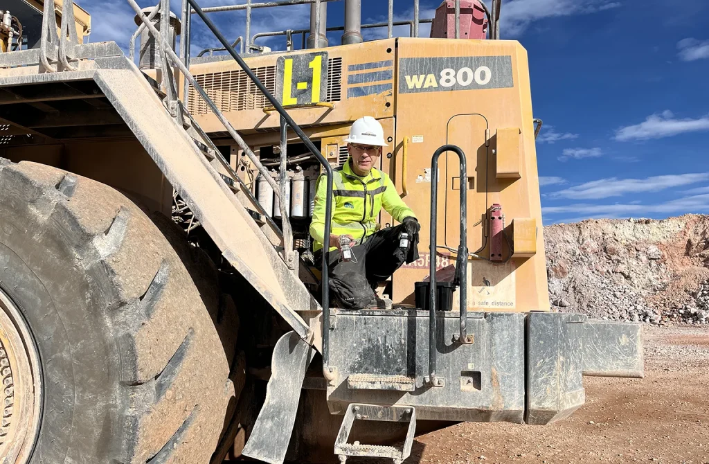 Technician analyzing oil samples from construction machinery to assess engine wear.