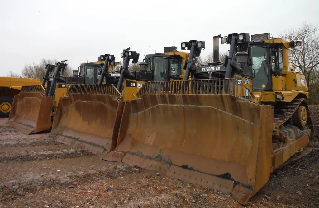 A wide array of heavy construction equipment, including excavators, bulldozers, and cranes, displayed at an auction venue, ready for inspection by potential buyers.
